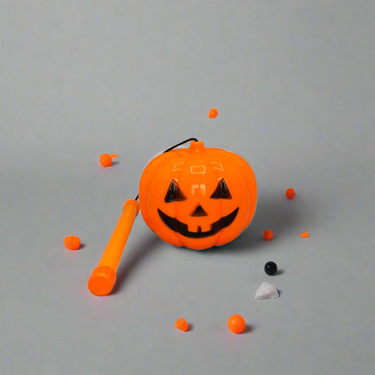 Orange Halloween candy holder with a black face on a gray background