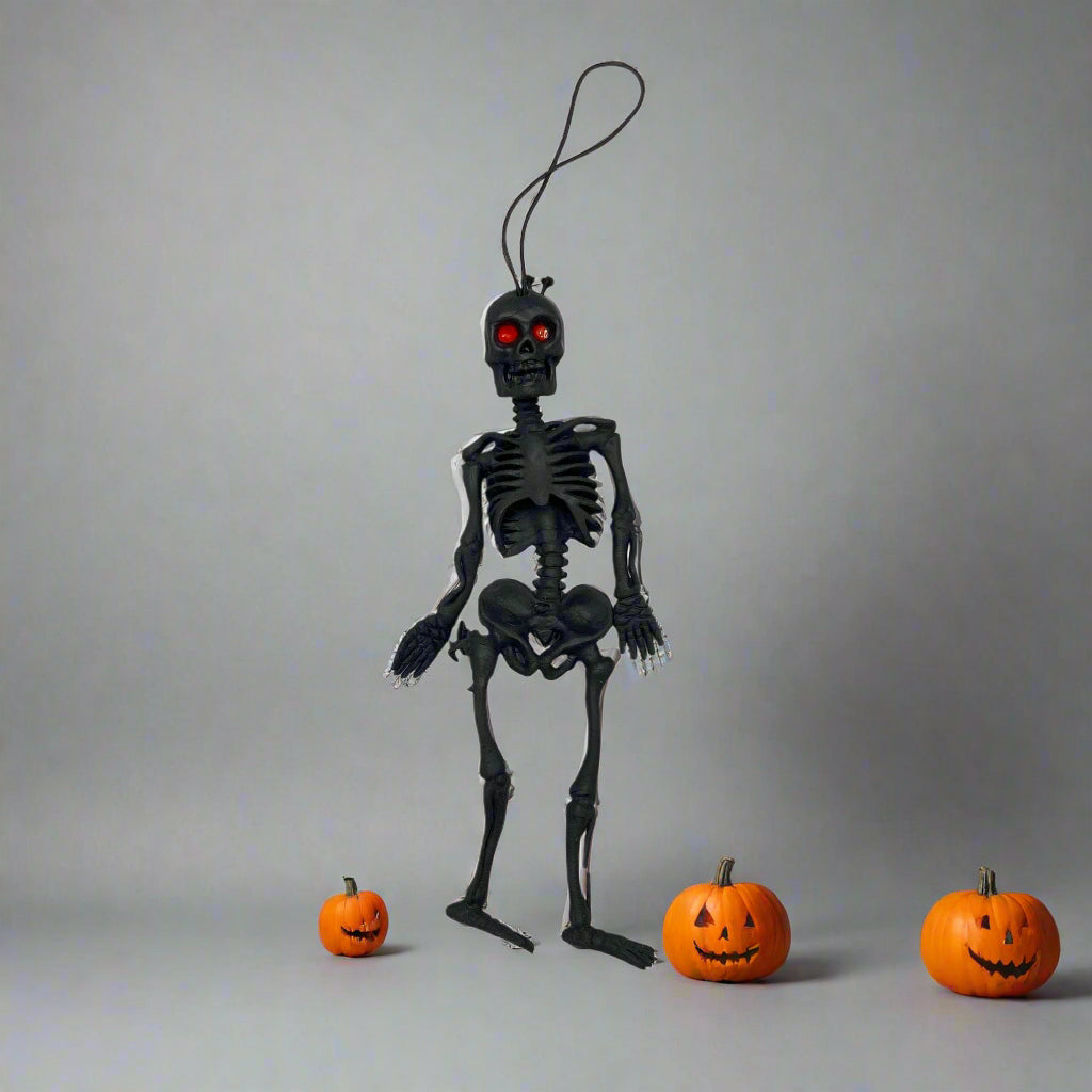 Black skeleton toy with red eyes on a white background