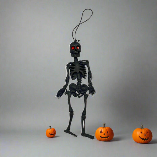 Black skeleton toy with red eyes on a white background