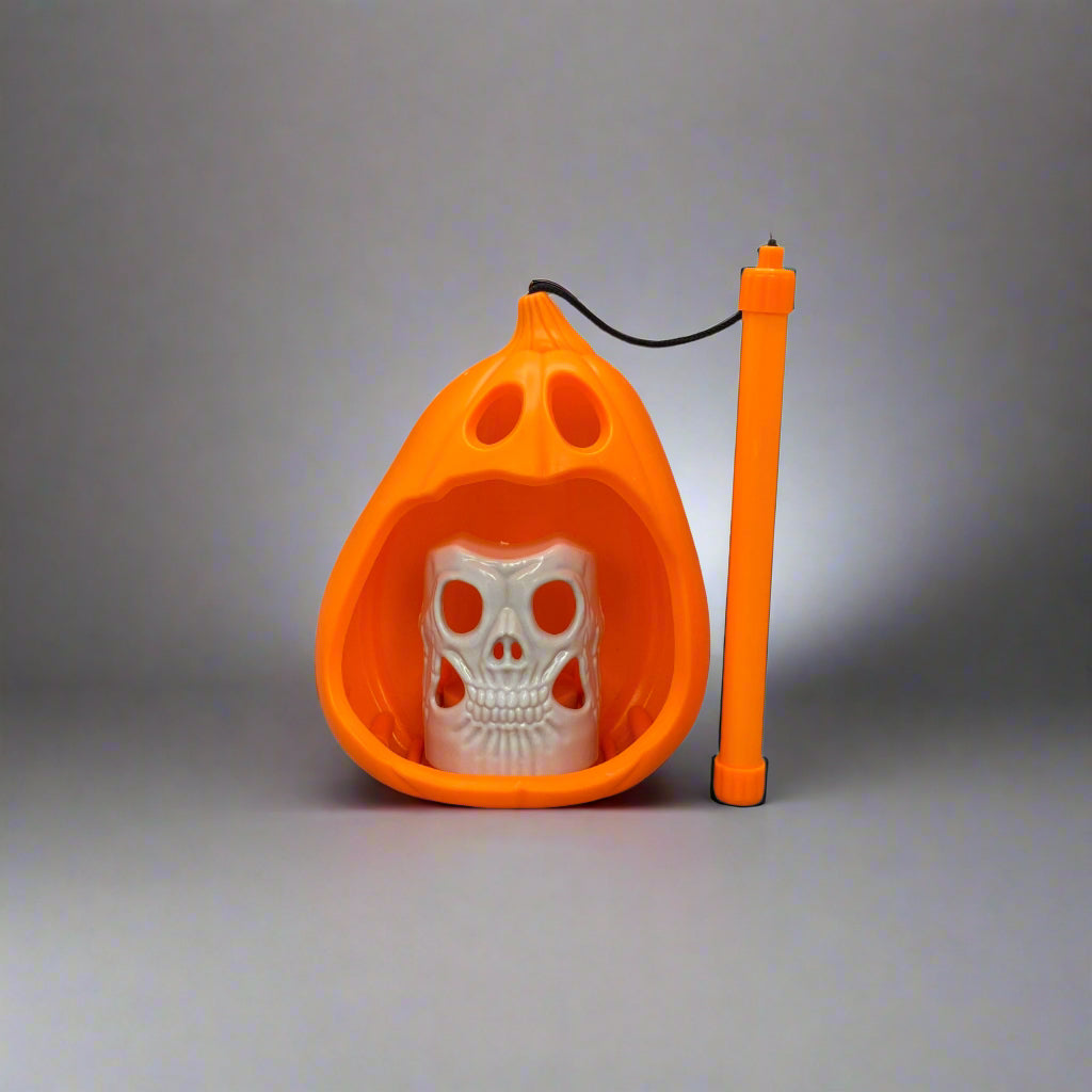 Orange pet potty trainer with white plastic base on a gray floor.