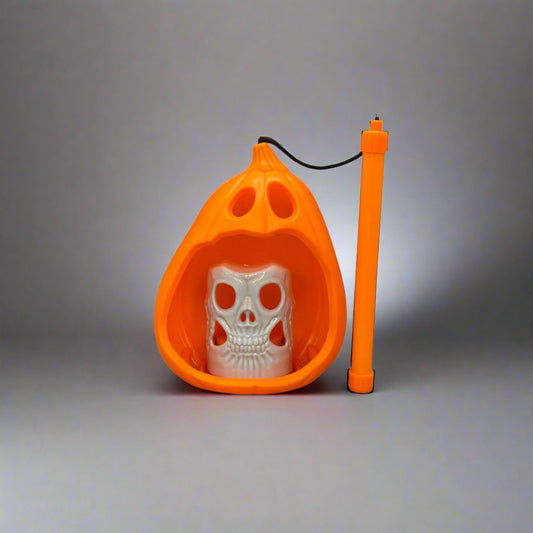 Orange pet potty trainer with white plastic base on a gray floor.