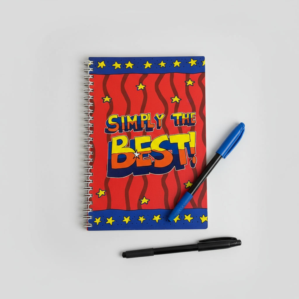Notebook with 'Simply the Best!' design on a desk with stationery items