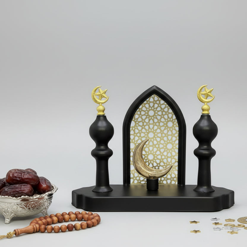 Decorative black and gold wall bracket on a gray wall