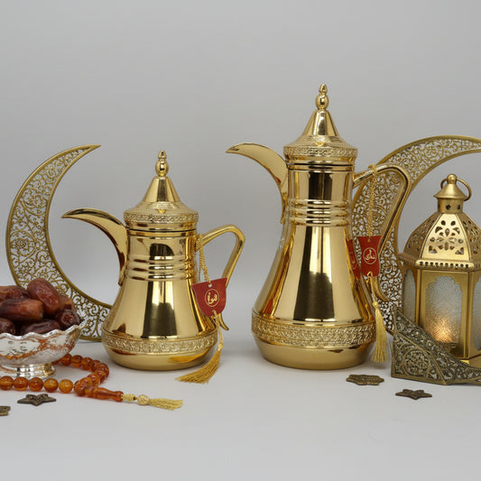 Two gold-colored coffee pots on a gray background