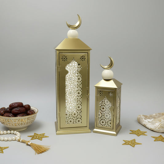 Decorative gold lanterns with intricate cut-out patterns on a gray wall.