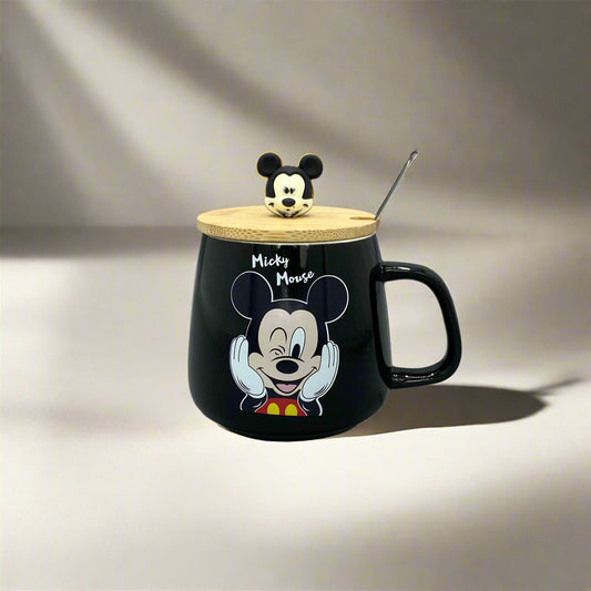 Black mug with cartoon character design on a gray surface